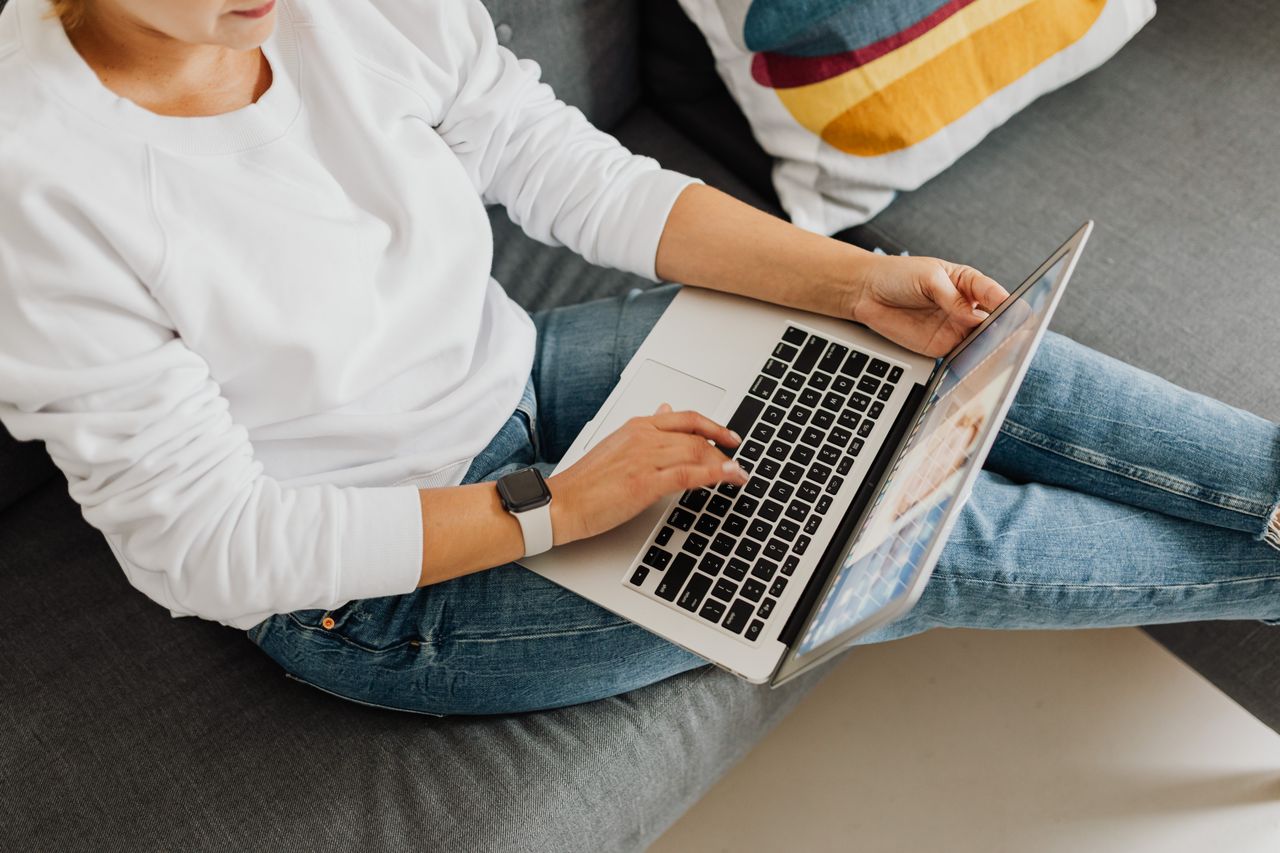 Professional reviewing continuing education materials on laptop
